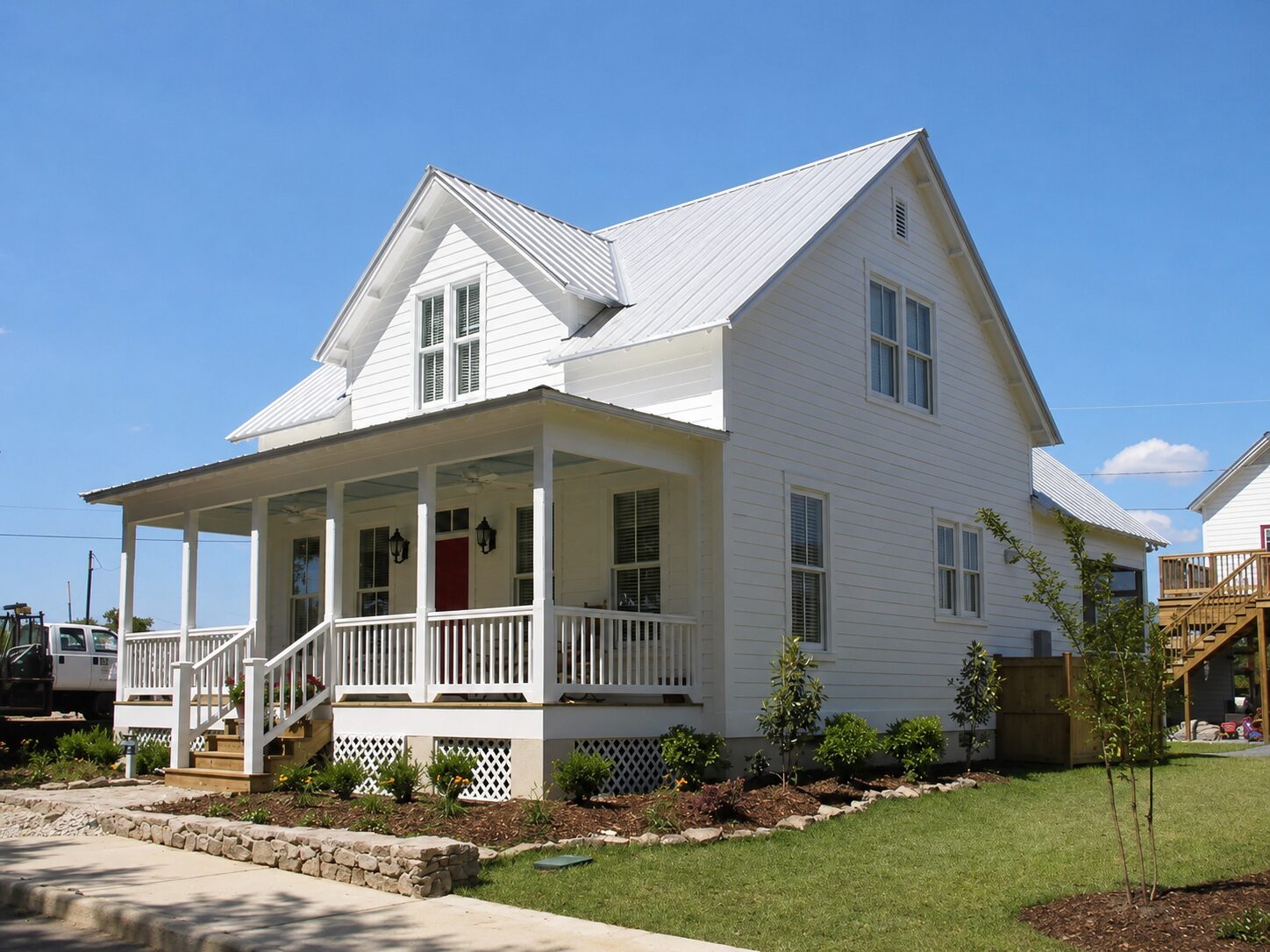 Two-story white farmhouse with a silver metal roof