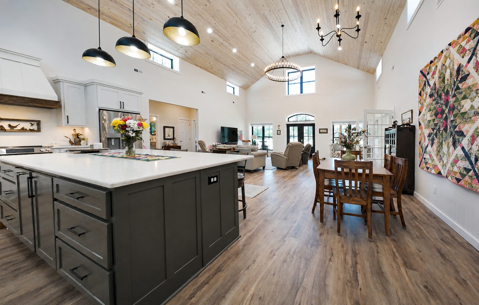 Open interior of a barndominium with vaulted ceiling and kitchen island